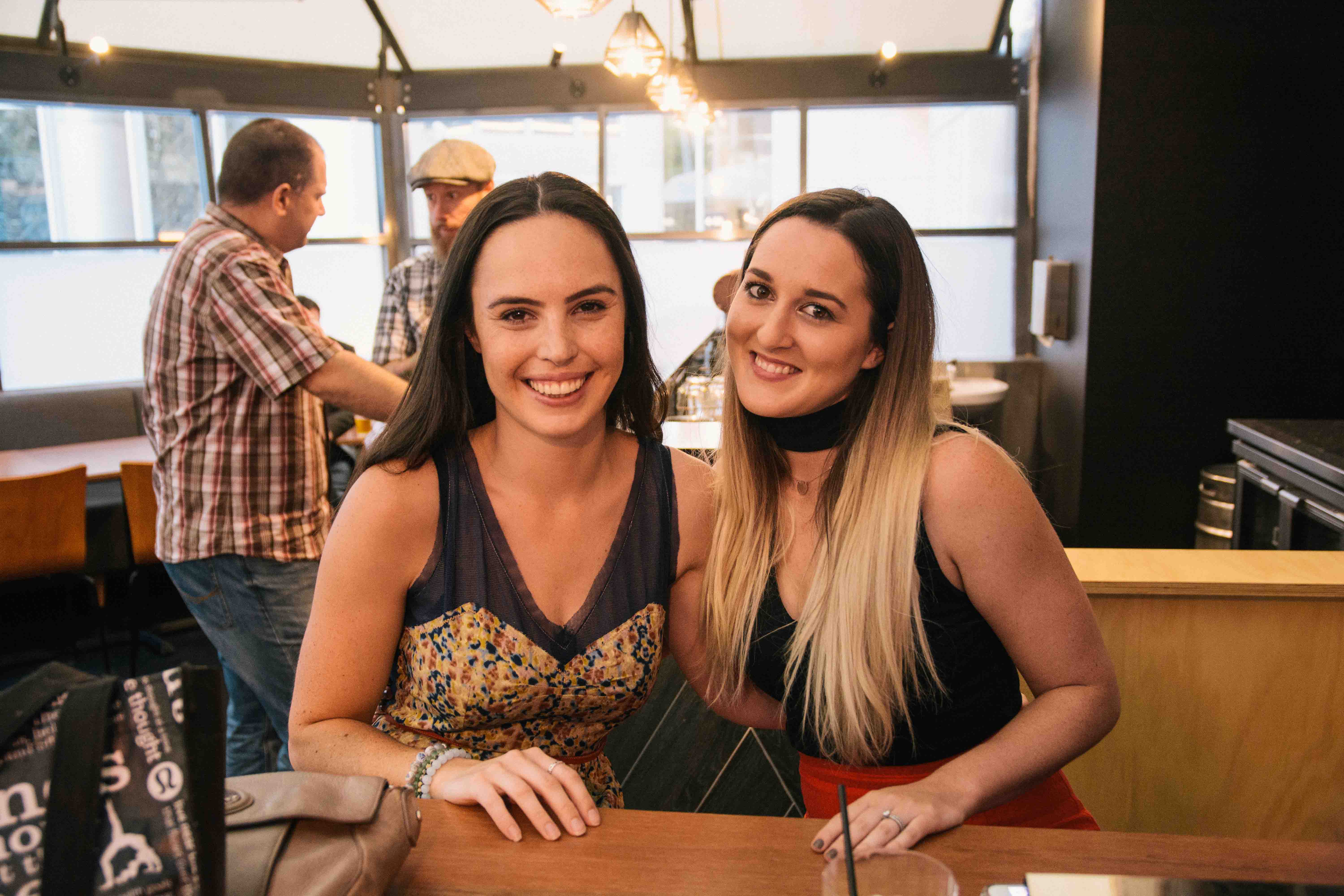 Two coworkers out in a bar in Perth CBD enjoying a drink after work